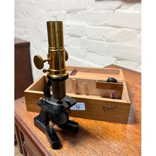 12 - A small brass and iron microscope in fitted box, stands 9 1/2