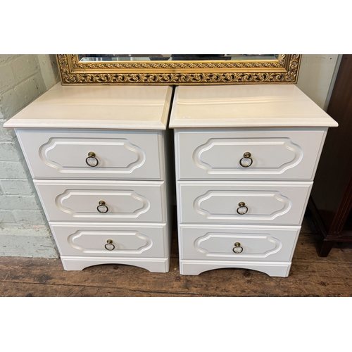 25 - A pair of modern white three drawer bedside chests