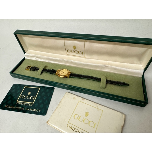 565 - Gucci - ladies quartz wrist watch on original black and green leather strap with original box, bookl... 