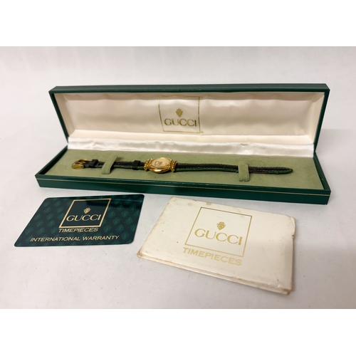 565 - Gucci - ladies quartz wrist watch on original black and green leather strap with original box, bookl... 