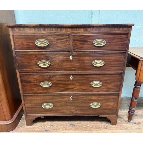 114 - A Georgian mahogany cross banded chest of two short and three long drawers with pressed brass handle... 