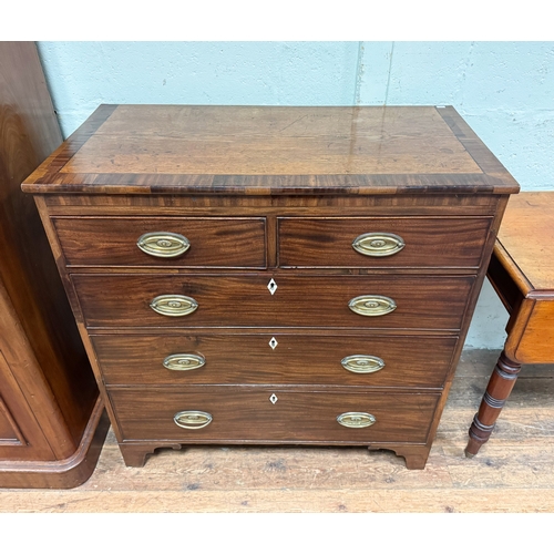 114 - A Georgian mahogany cross banded chest of two short and three long drawers with pressed brass handle... 