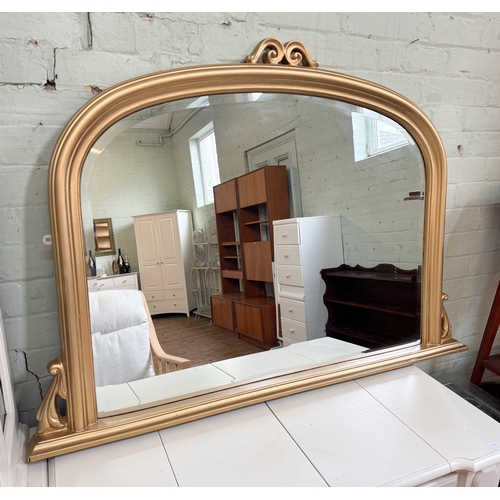 67 - A Victorian style gilt painted arched over mantel mirror