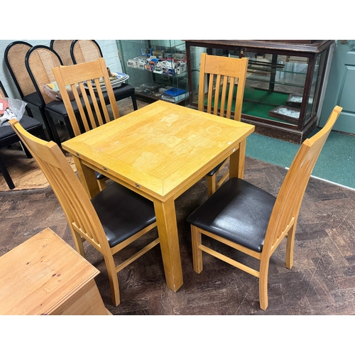 142 - A square modern light oak dining table and four matching slat back chairs with faux brown leather se... 