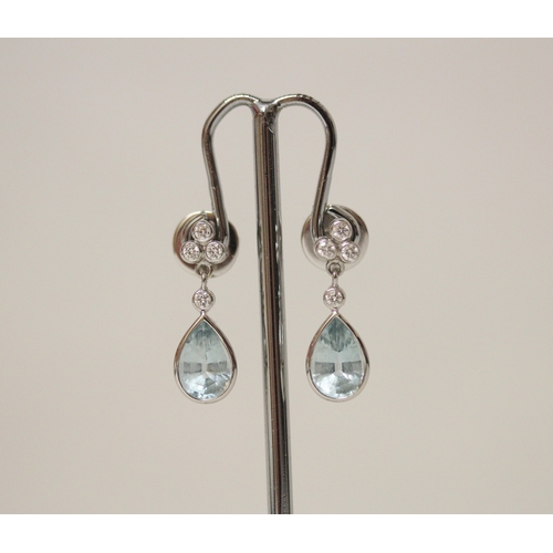 462 - A pair of quality aquamarine and diamond modern drop earrings. The tear drop aquamarines suspended f... 