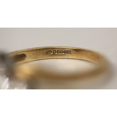 424 - A three stone diamond ring, the three brilliant cut diamonds claw set in a offset cross over twist d... 