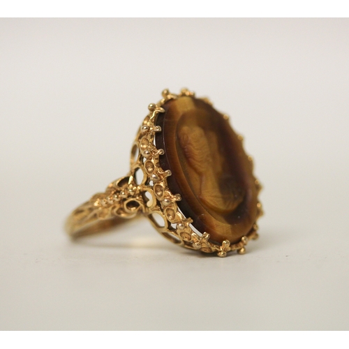 429 - A carved tigers eye cameo dress ring, claw set on 9ct gold band, ring size N. Gross weight 5.8g