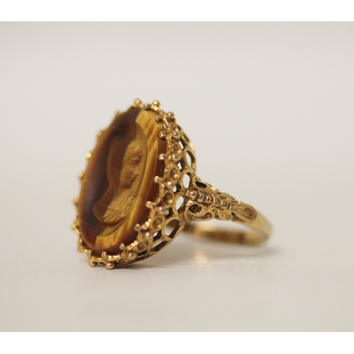 429 - A carved tigers eye cameo dress ring, claw set on 9ct gold band, ring size N. Gross weight 5.8g