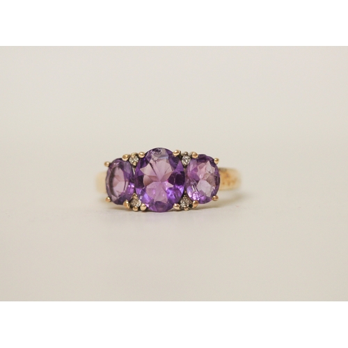 440 - A three stone amethyst and diamond dress ring on hallmarked 9ct gold band. Ring size P, 3.8g