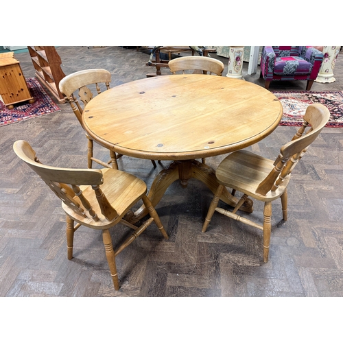 285 - A modern pine single pillar circular dining table, 4' diameter, together with a set of four Windsor ... 
