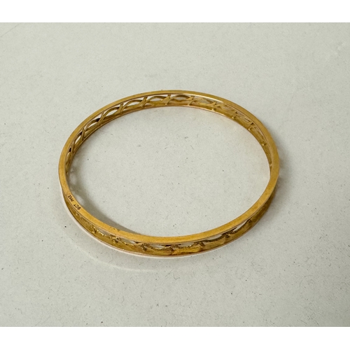 390A - 9ct gold pierced bangle with engraved decoration to the centre panels. 13.4g