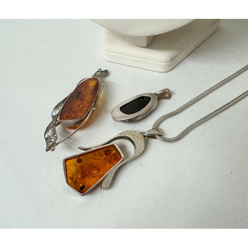 403 - Three large amber statement pendants, set in silver with a silver snake link chain