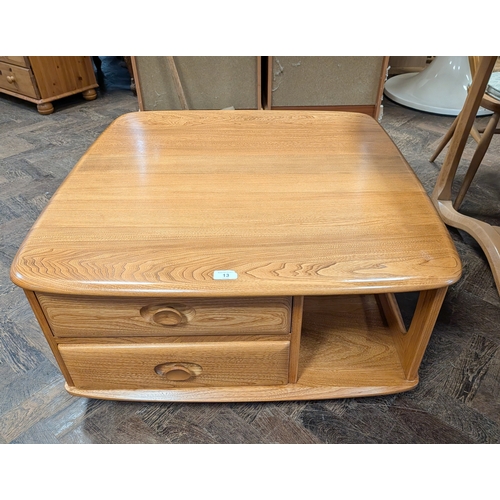 13 - An Ercol blond elm Pandora square coffee table fitted two drawers...