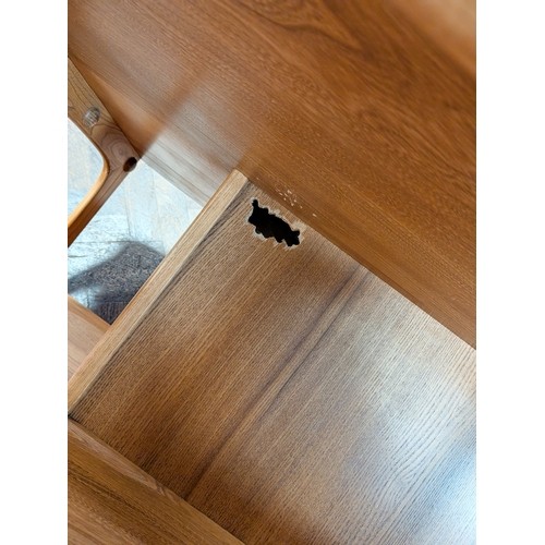 13 - An Ercol blond elm Pandora square coffee table fitted two drawers...