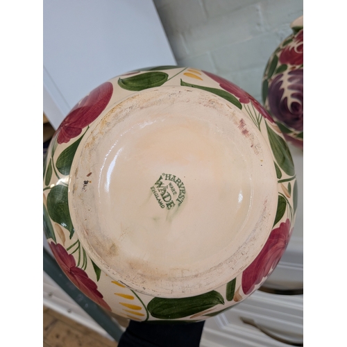 34 - A pair of floral decorated Wade bulbous china vases...