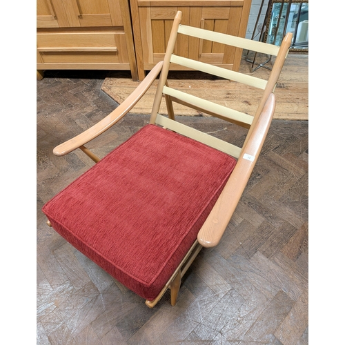 11 - An Ercol  mid-century fireside chair, model 442,  with sloping arms and red cushions...