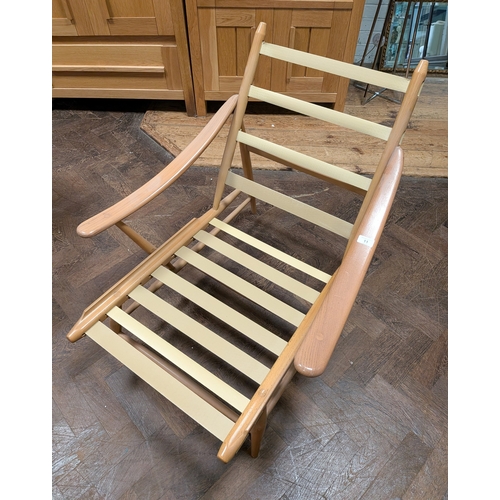 11 - An Ercol  mid-century fireside chair, model 442,  with sloping arms and red cushions...
