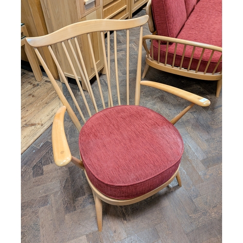 12 - An Ercol blond elm fireside chair with red seat and back cushions...