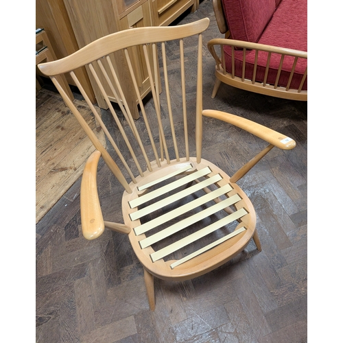 12 - An Ercol blond elm fireside chair with red seat and back cushions...