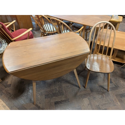14 - An Ercol blond elm dropleaf dining table together with one similar stick back chair...