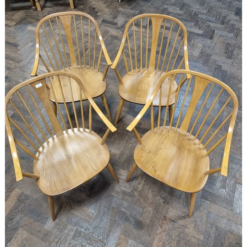 3 - Ercol  - a set of four Cowhorn 524 blond elm elbow or carver chairs with loose blue patterned cushio...