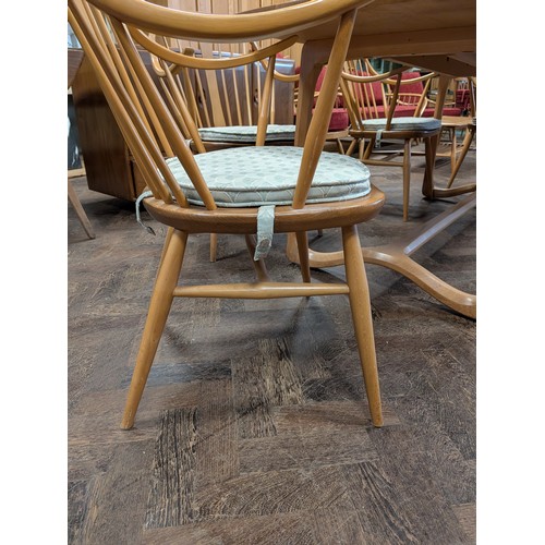 3 - Ercol  - a set of four Cowhorn 524 blond elm elbow or carver chairs with loose blue patterned cushio...