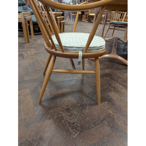 3 - Ercol  - a set of four Cowhorn 524 blond elm elbow or carver chairs with loose blue patterned cushio...