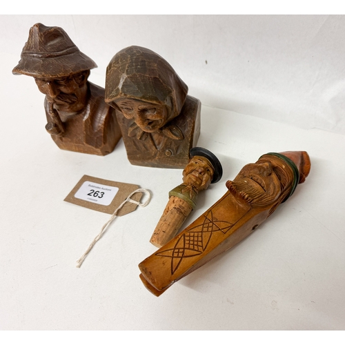 107 - Four wooden Austrian carved figures to include a novelty pair of nutcrackers and bottle stopper