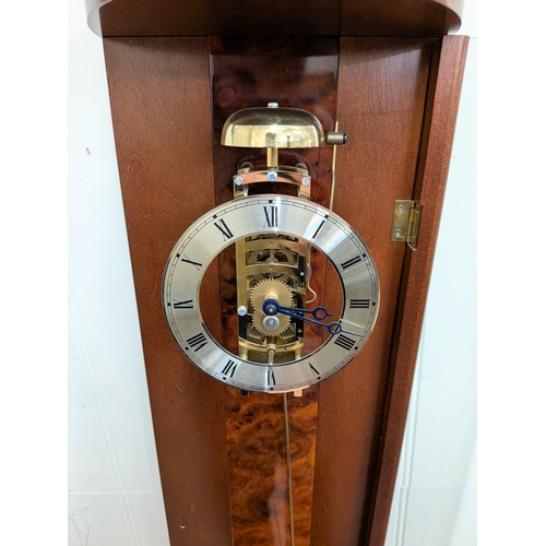 50 - A modern skeleton wall clock in bow fronted glass case with striking movement