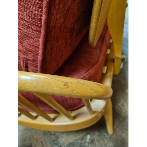 10 - An Ercol blond elm sofa/day bed, model 355, with red cushions...