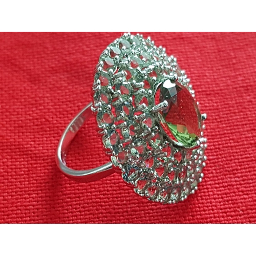 244 - White Metal Ring with Large Oval Light Green Stone and Quantity of Small Stones Size P/Q (17/18)