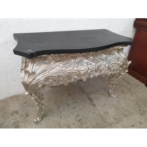 105 - A Console Table, Shaped Black Top on an Eleborate Silvered Base (120cm x 6cm x H:83cm) (Ref: FUR 801... 