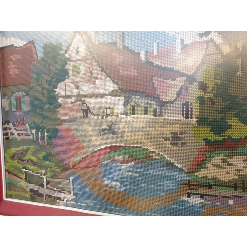 307 - Large Tapestry of Riverside Village Scene in Decorative Gilt Frame (118cm x 68cm overall)