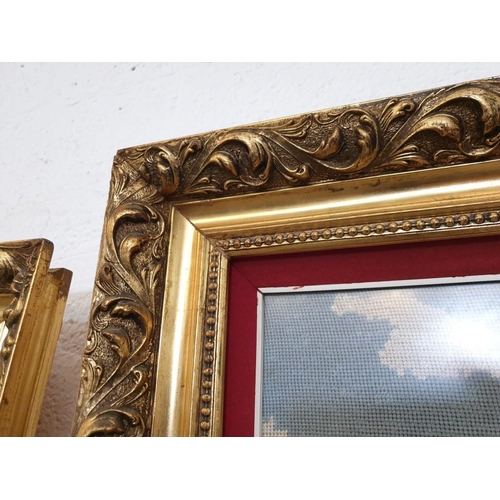 307 - Large Tapestry of Riverside Village Scene in Decorative Gilt Frame (118cm x 68cm overall)