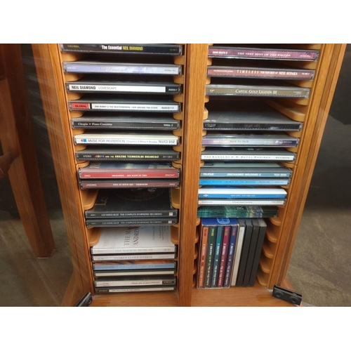 78 - Pine Colour CD Cabinet with Glass Doors and Collection of Assorted CD's (39 x 22 x 78cm)
