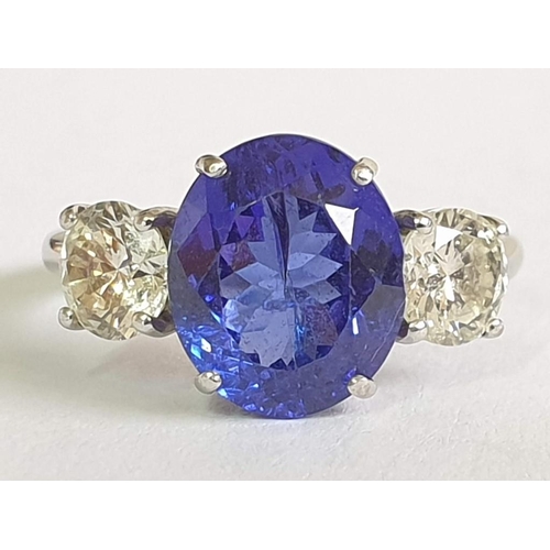 120A - 18ct Gold Tanzanite and Diamond Ring; 5.21ct Oval Cut Tanzanite (Approx 11.3 x 9.4mm Overall) with 2... 