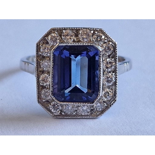 164 - Platinum, Tanzanite and Diamond Ring; Emerald Cut Tanzanite, (Approx. 9x7mm), with 16 x Round Cut Di... 