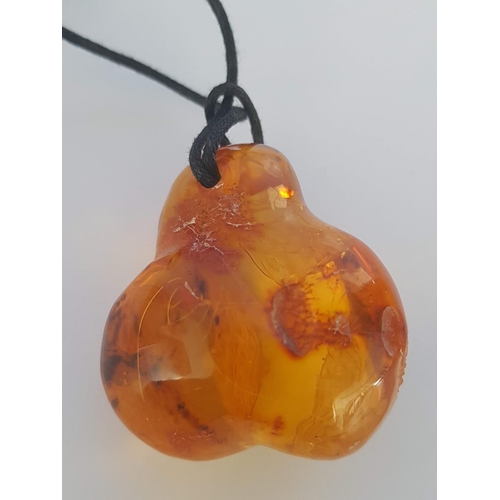 149 - Lathe Unique Amber (?) Pendant on String (Approx 4.5 x 3.5cm)