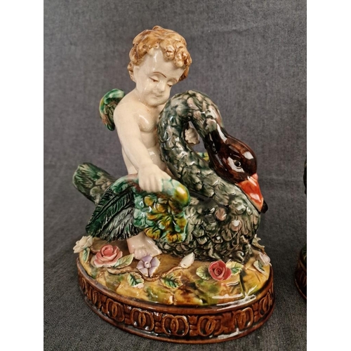 125 - 2 x Continental Style Porcelain Cherubs Playfully Riding Swans, (Approx. H: 22cm, Base: 20 x 15.5cm ... 