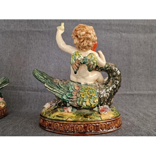 125 - 2 x Continental Style Porcelain Cherubs Playfully Riding Swans, (Approx. H: 22cm, Base: 20 x 15.5cm ... 