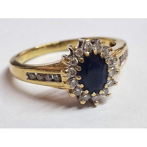 103 - 18ct Gold, Sapphire and Diamond Ring; Central Oval Cut Sapphire, (Approx. 7 x 5mm) with Surrounding ... 