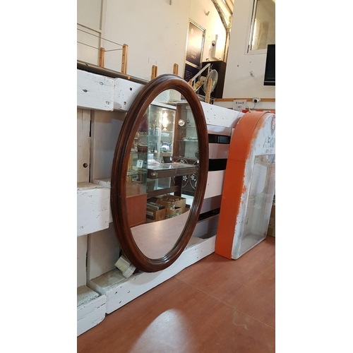 68 - Large oval mirror in an Edwardian oak frame – 77cm x 57