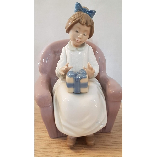 134 - Nao by Lladro 'Birthday Girl' (Girl Carrying Gift and Setting on Armchair), Porcelain Figurine, Made... 