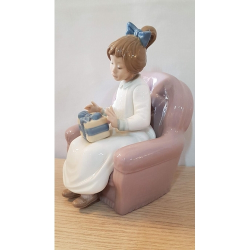 134 - Nao by Lladro 'Birthday Girl' (Girl Carrying Gift and Setting on Armchair), Porcelain Figurine, Made... 