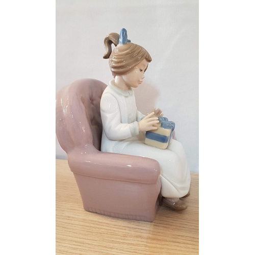 134 - Nao by Lladro 'Birthday Girl' (Girl Carrying Gift and Setting on Armchair), Porcelain Figurine, Made... 