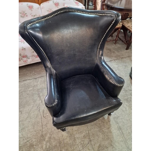 7 - Black Leather Effect Wingback Armchair with Studded Surround Over Turned Front Legs with Casters