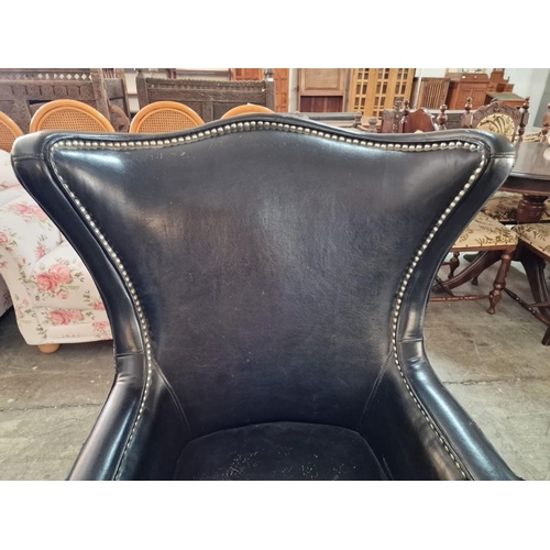 7 - Black Leather Effect Wingback Armchair with Studded Surround Over Turned Front Legs with Casters