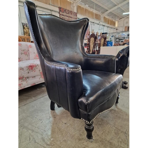 7 - Black Leather Effect Wingback Armchair with Studded Surround Over Turned Front Legs with Casters