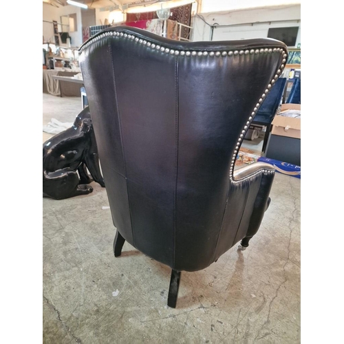 7 - Black Leather Effect Wingback Armchair with Studded Surround Over Turned Front Legs with Casters