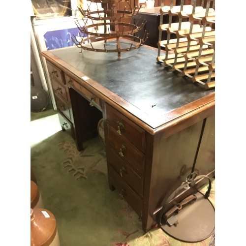 103 - Late Edwardian mahogany knee hole desk with tooled leather top.